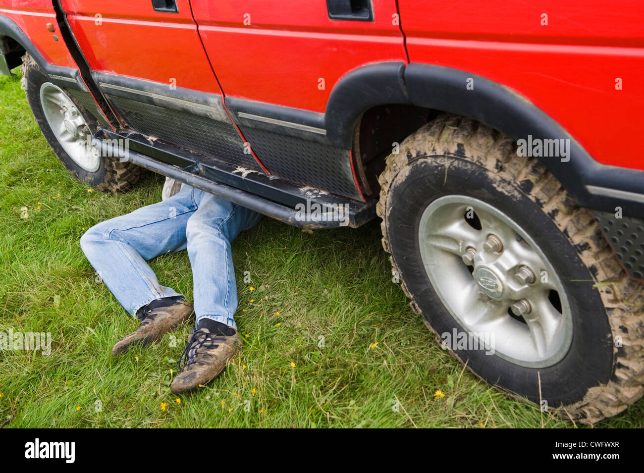 L'homme de travailler sous Land Rover Discovery Land Rover à Eastnor annuel Show Herefordshire Angleterre UK Banque D'Images