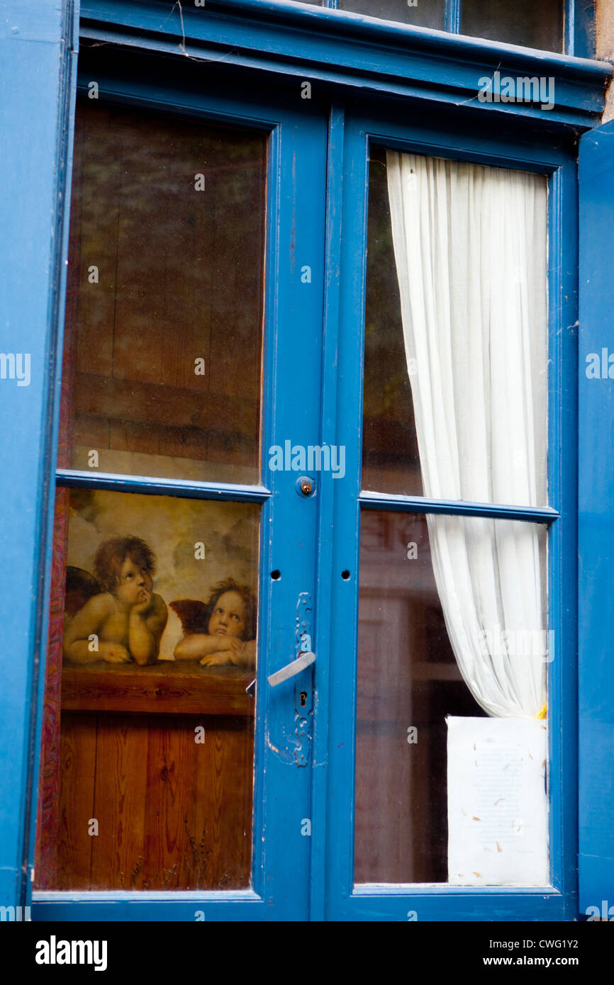 Un 'petit ange' Photo de Raphaël, au moyen d'un cadre de fenêtre bleu à Saint Emilion, dans le sud de la France Banque D'Images