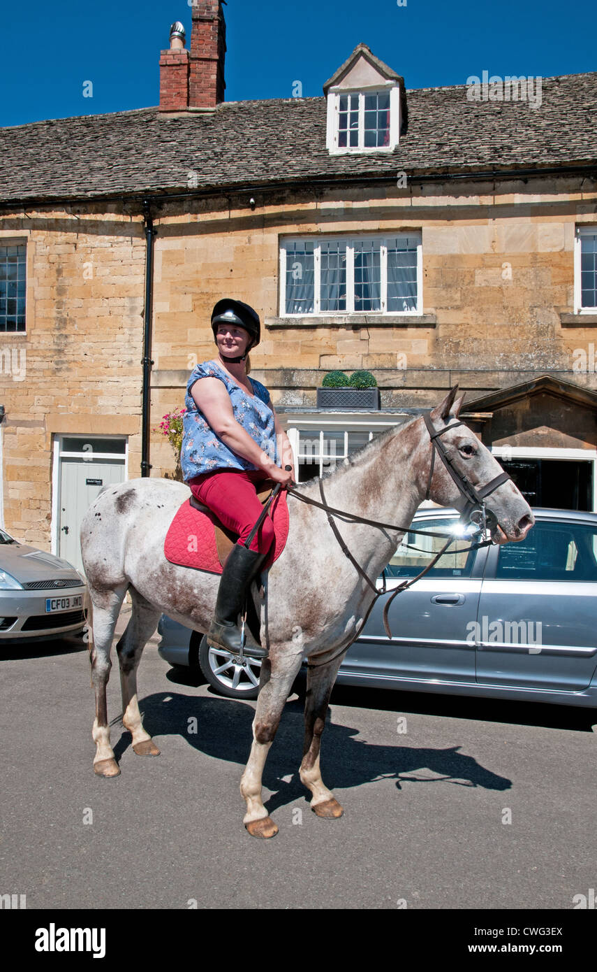 Dame horse rider sur High Street à Chipping Campden Gloucestershire Angleterre Banque D'Images