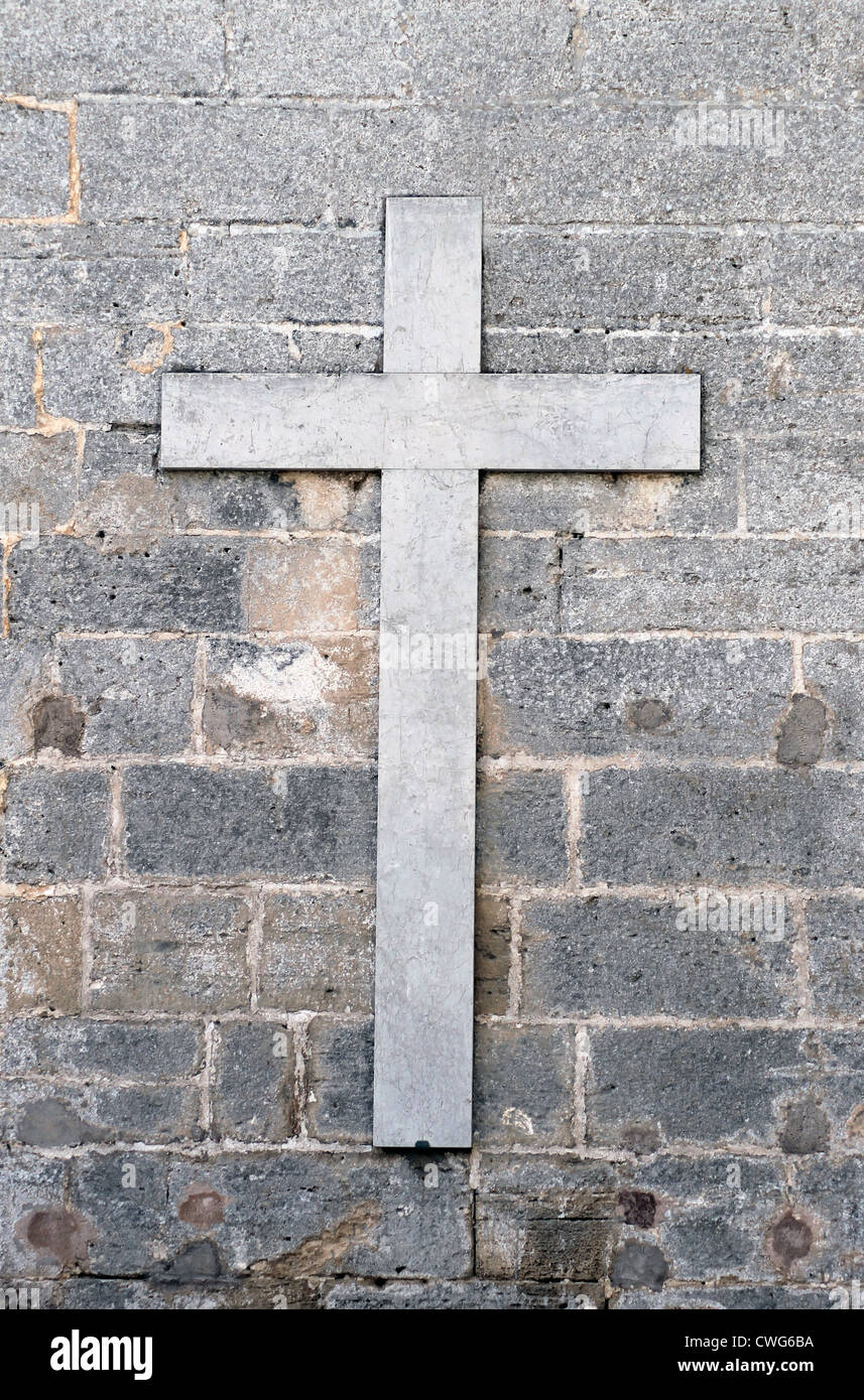 Ancienne croix religieuse en marbre gris ou gris sur le mur. Banque D'Images