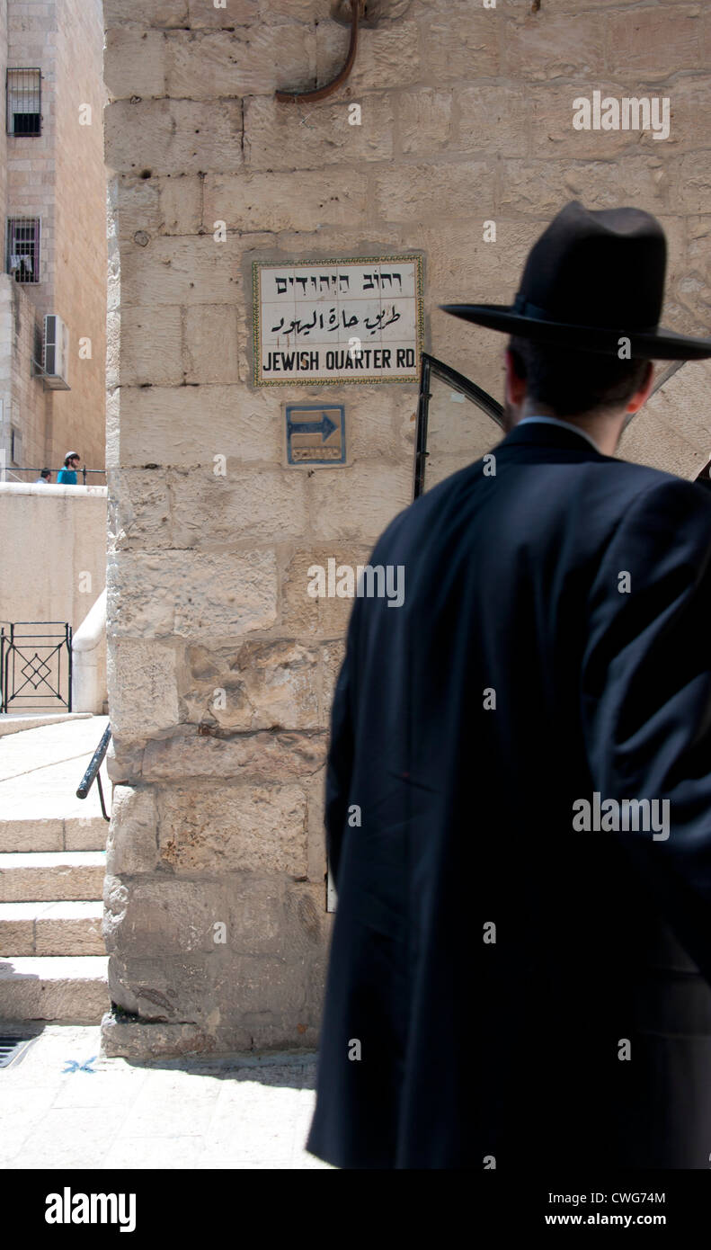 Un homme juif d'œil à un signe pour le quartier juif à Jérusalem, Israël Banque D'Images