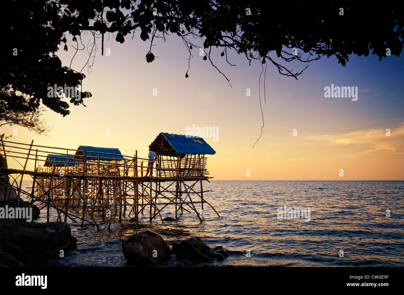 Plage des Huttes sur pilotis nipa bambou au coucher du soleil Banque D'Images