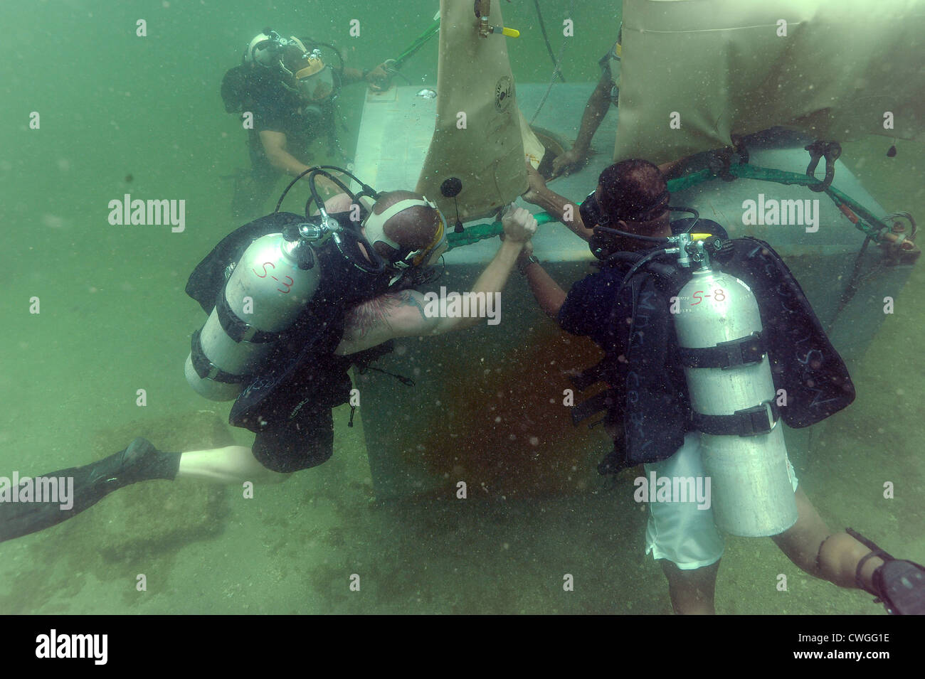 Un plongeur de la marine américaine un sac de levage crochets à un objet avec l'aide de la Trinité-et-Tobago plongeurs. L'USNS Pince est participant au partenariat sud de plongeurs de la Marine, une multinationale de 2012 Station d'engagement de partenariat visant à accroître l'interopérabilité et nation partenaire la capacité grâce à des opérations de plongée. Banque D'Images