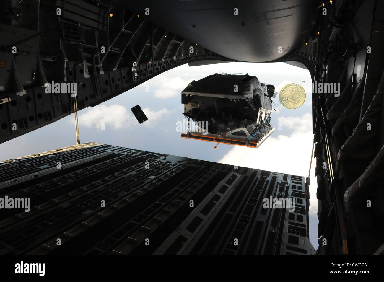 Un bateau vole hors de l'arrière d'un C-17 Globemaster III le 9 avril 2012, sur la base navale de l'océan entourant l'île lors d'une mission de formation. Au cours de la mission, l'équipage a chuté de membres du personnel de première ligne statique, l'équipement lourd de plates-formes, des ensembles de systèmes de livraison de conteneurs, des CD de faible vitesse, et des faisceaux de basse à haute altitude-ouverture de cavaliers pendant leur temps à Guam. Banque D'Images