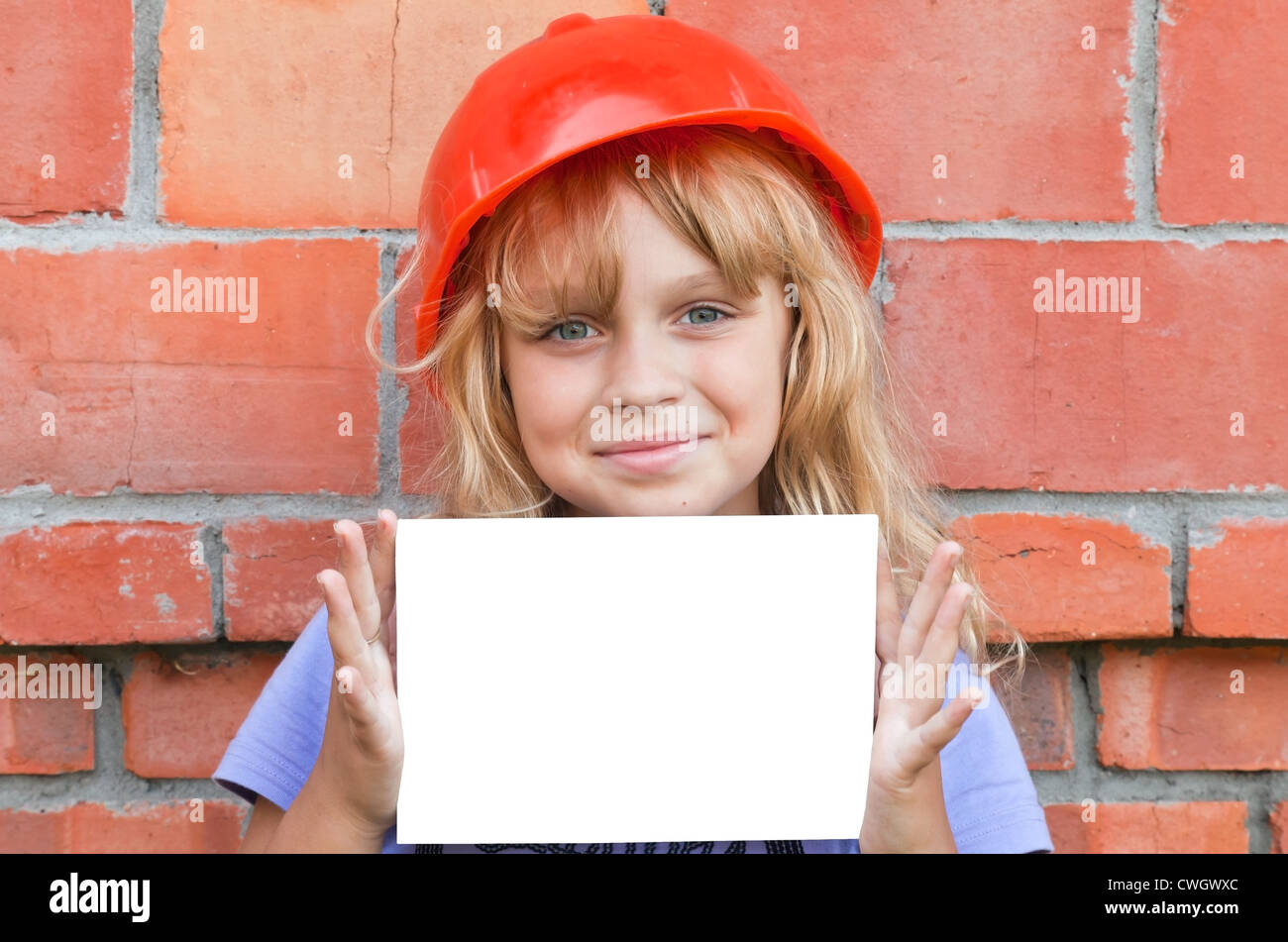 Portrait of a young girl with helmet de travailleur de la construction et blanc carte vierge Banque D'Images