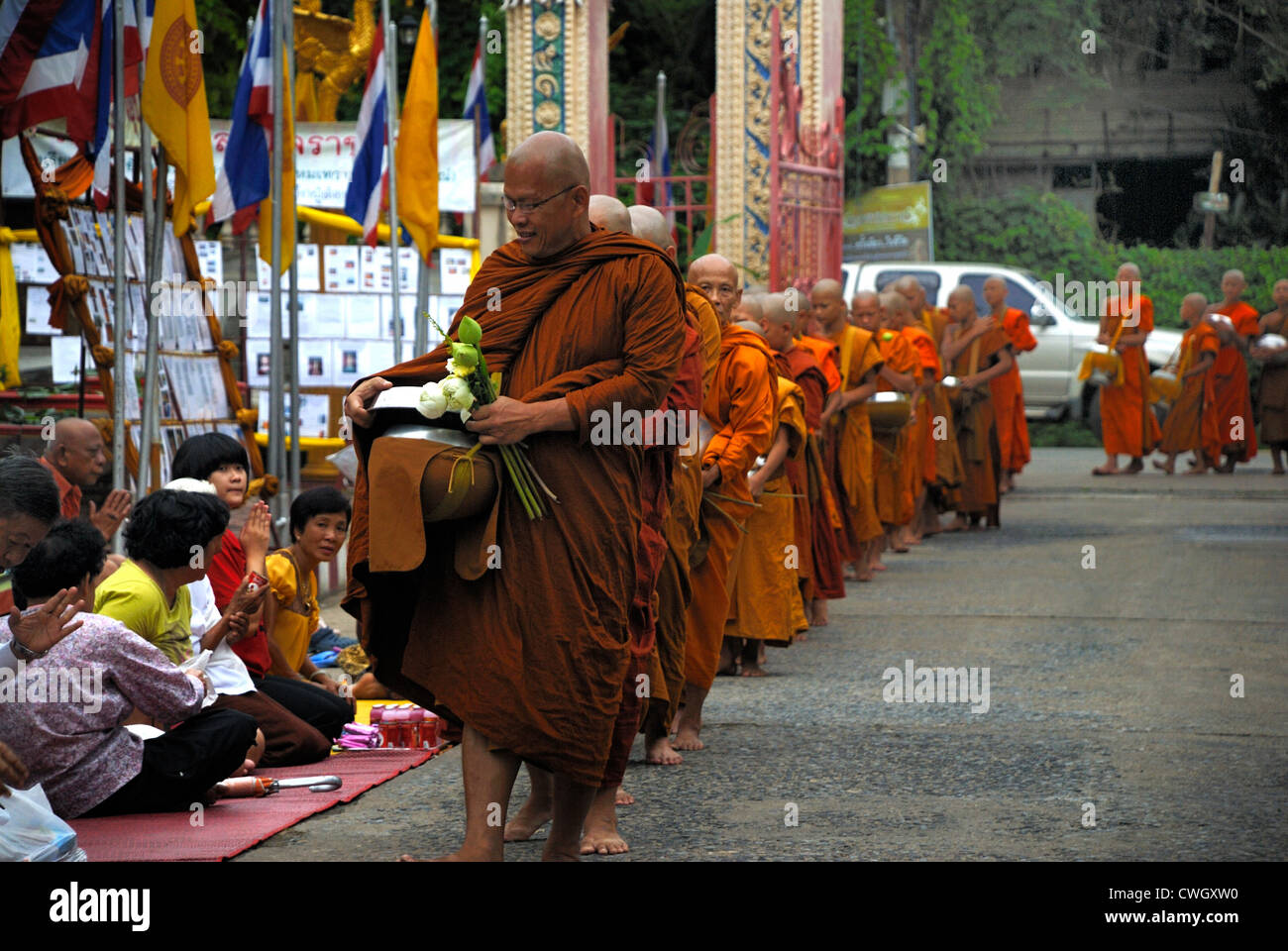 Moines recevant de la nourriture et de vos articles sur le carême bouddhiste Bouddha(jour) sur 12/08/2012 dans le nord-est de la Thaïlande Ubon Ratchathani Banque D'Images