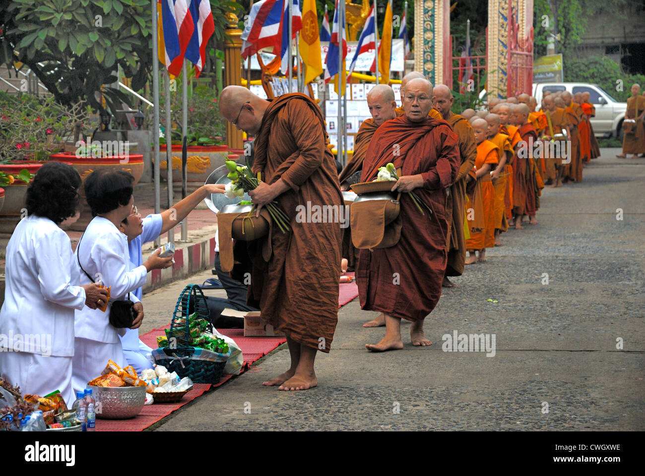 Moines recevant de la nourriture et de vos articles sur le carême bouddhiste Bouddha(jour) sur 12/08/2012 dans le nord-est de la Thaïlande Ubon Ratchathani Banque D'Images