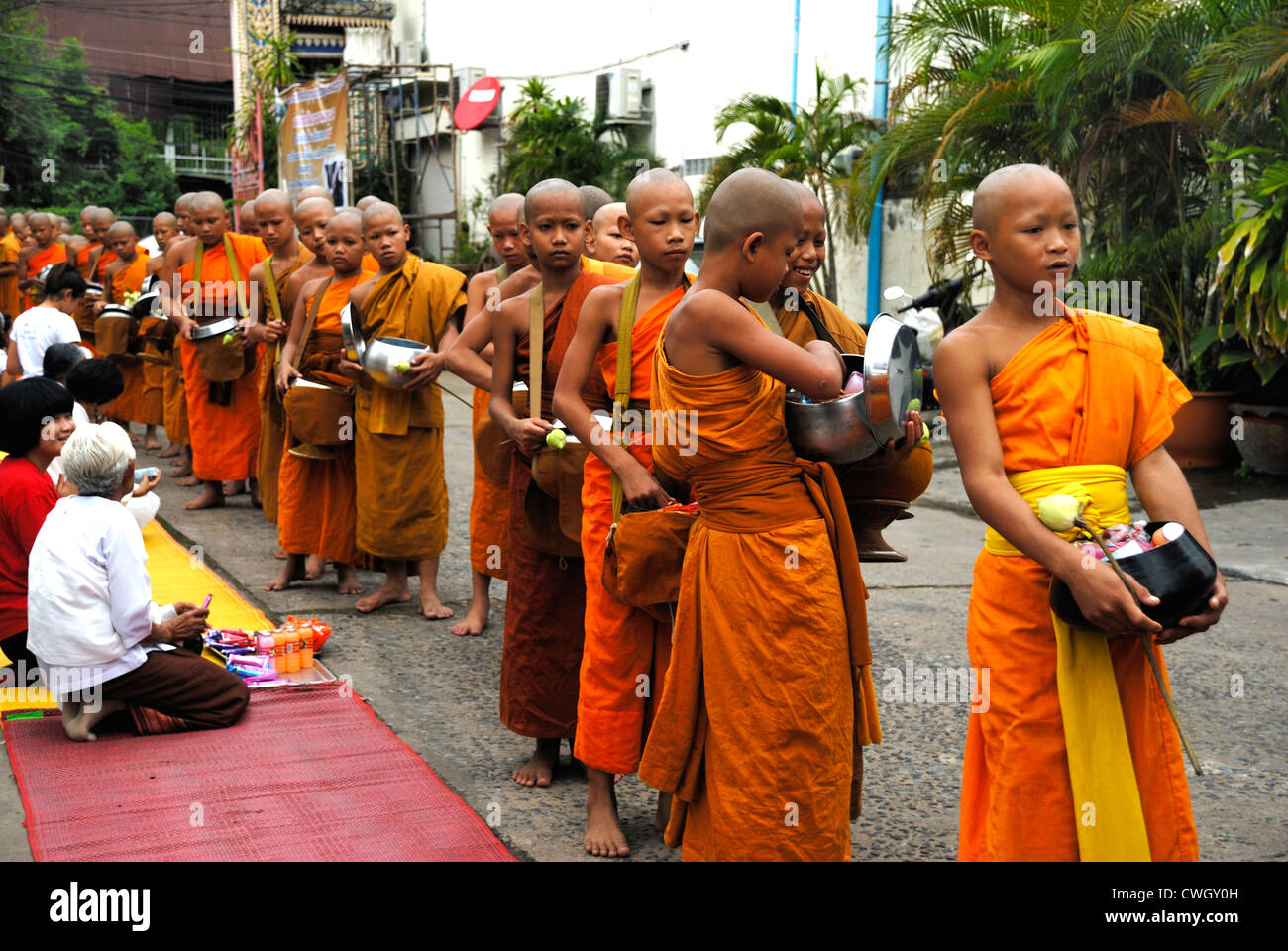 Moines recevant de la nourriture et de vos articles sur le carême bouddhiste Bouddha(jour) sur 12/08/2012 dans le nord-est de la Thaïlande Ubon Ratchathani Banque D'Images