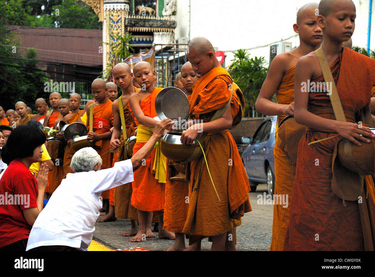 Moines recevant de la nourriture et de vos articles sur le carême bouddhiste Bouddha(jour) sur 12/08/2012 dans le nord-est de la Thaïlande Ubon Ratchathani Banque D'Images