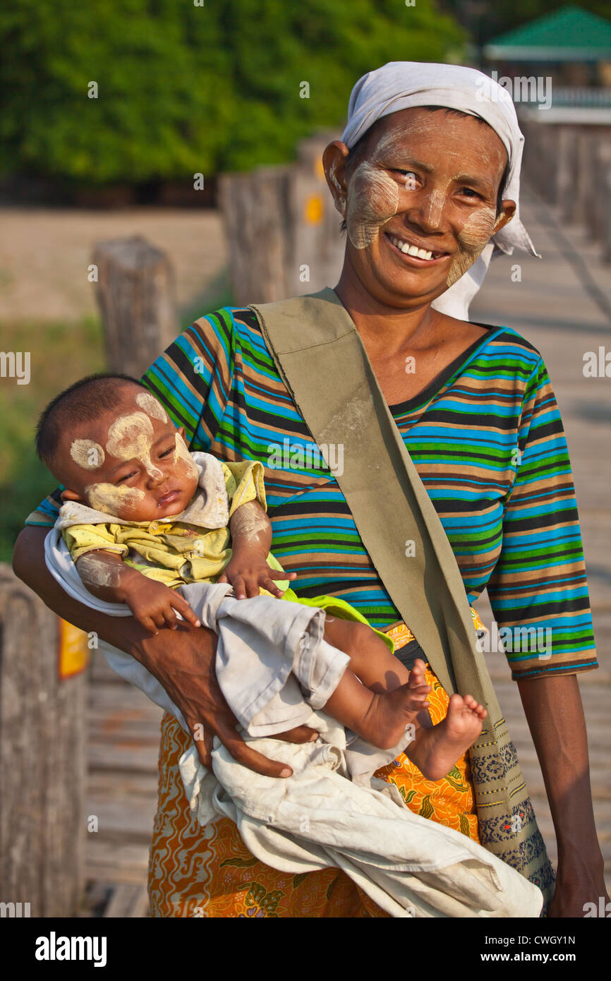 Une mère birmane avec bébé utilise le pont en teck U BEINS de commuer à travers le lac Taungthaman - AMARAPURA, MYANMAR Banque D'Images