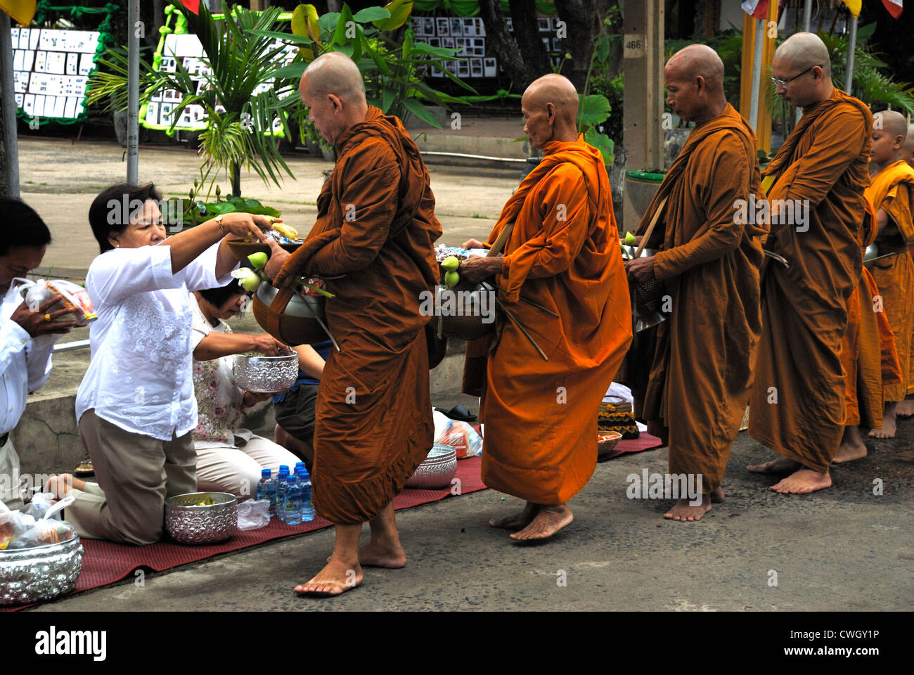Moines recevant de la nourriture et de vos articles sur le carême bouddhiste Bouddha(jour) sur 12/08/2012 dans le nord-est de la Thaïlande Ubon Ratchathani Banque D'Images