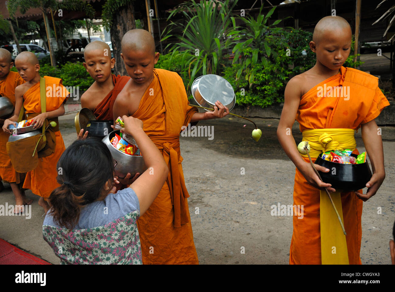 Moines recevant de la nourriture et de vos articles sur le carême bouddhiste Bouddha(jour) sur 12/08/2012 dans le nord-est de la Thaïlande Ubon Ratchathani Banque D'Images