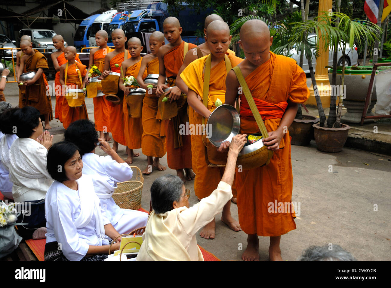 Moines recevant de la nourriture et de vos articles sur le carême bouddhiste Bouddha(jour) sur 12/08/2012 dans le nord-est de la Thaïlande Ubon Ratchathani Banque D'Images