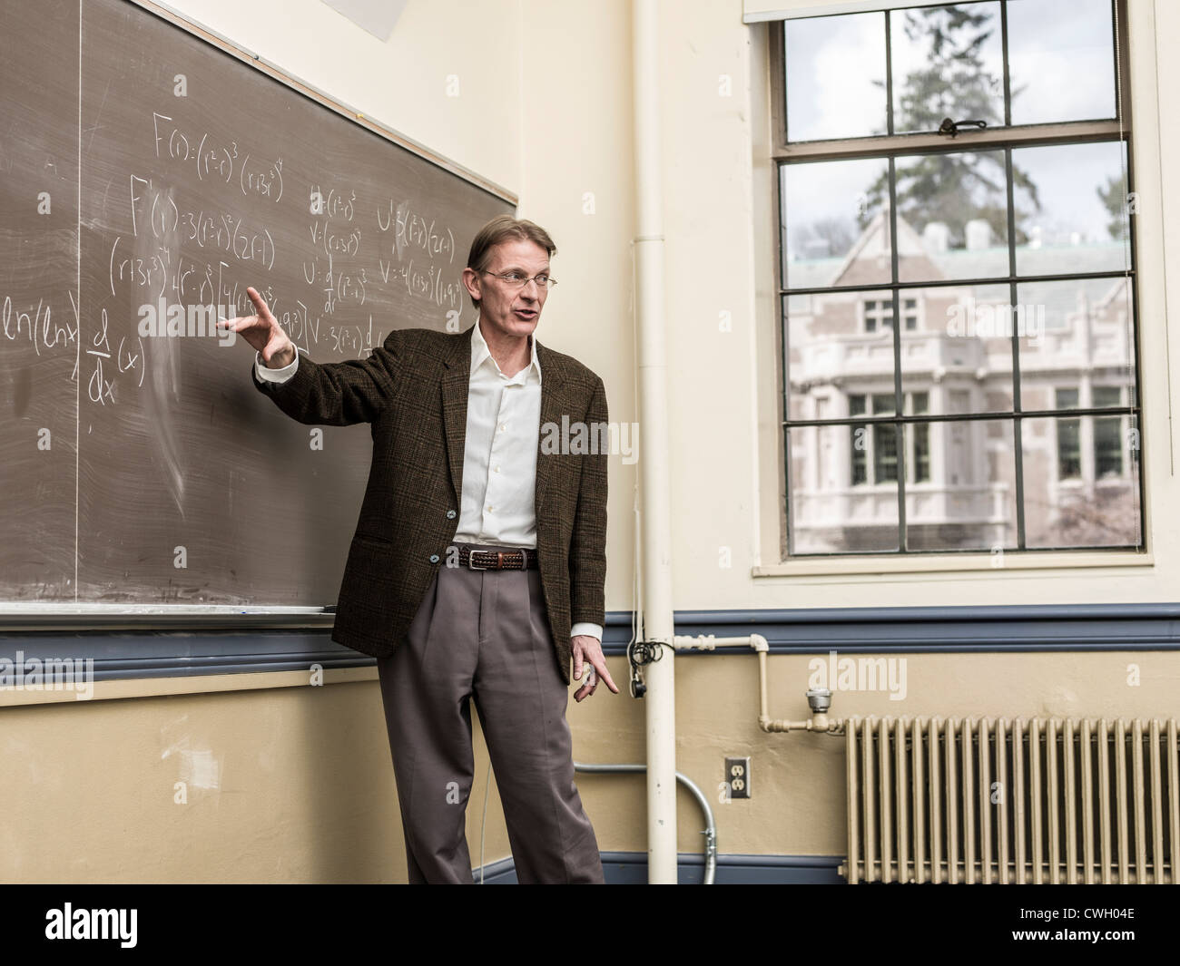 Caucasian teacher writing on blackboard Banque D'Images