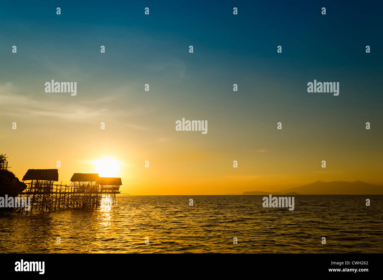 Silhouette de nipa plage huttes sur pilotis en bambou pendant le coucher du soleil Banque D'Images