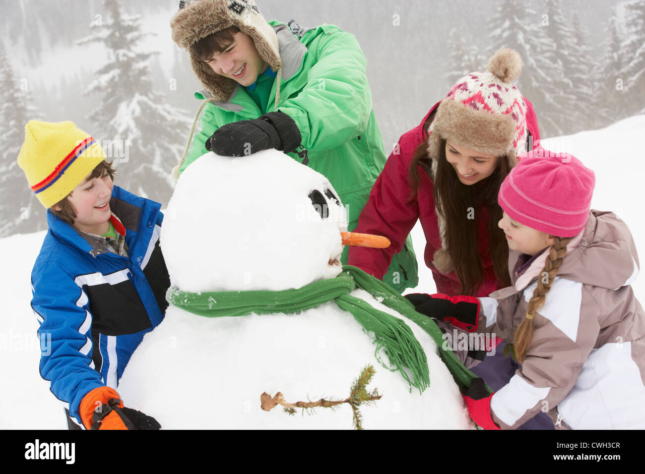 Groupe d'enfants Bonhomme de bâtiment sur vacances de neige en montagne Banque D'Images