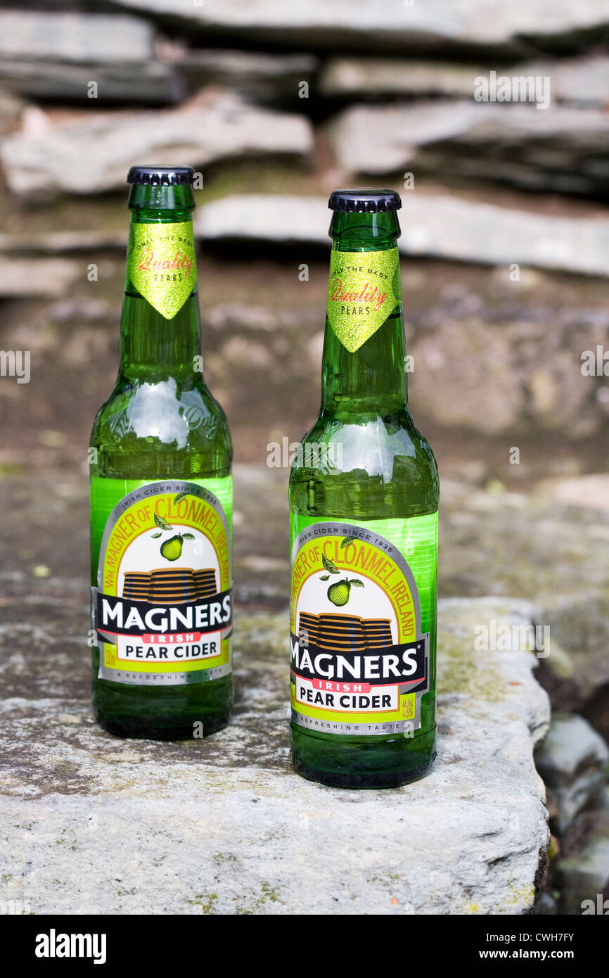 Bouteilles de cidre Magners pear sur un mur de pierre. Banque D'Images