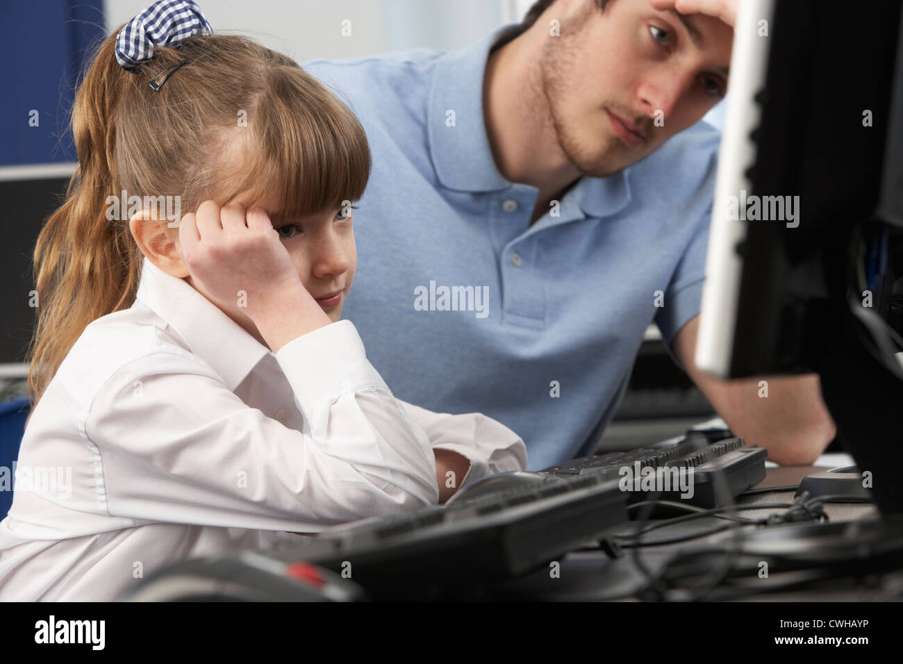 Enseignant et malheureux à l'aide d'un ordinateur dans la classe fille Banque D'Images