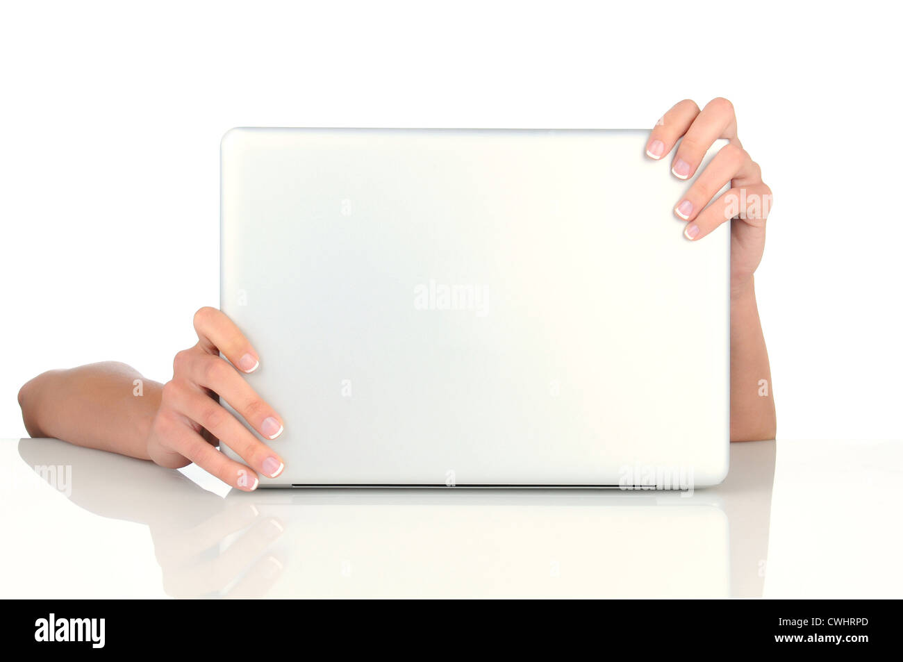 A woman's hands holding les coins de son ordinateur portable qu'elle est assise sur son bureau avec la réflexion. Banque D'Images