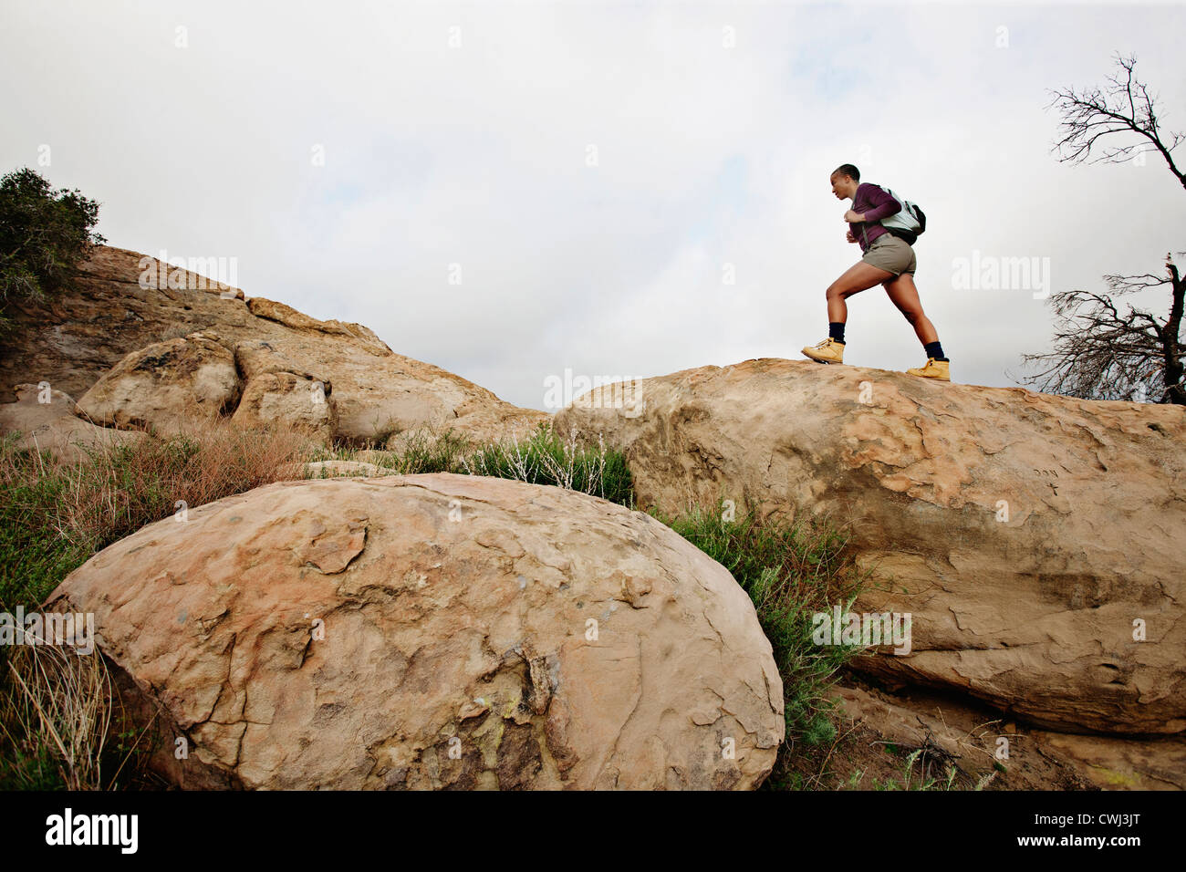 Black woman hiking sur les roches Banque D'Images