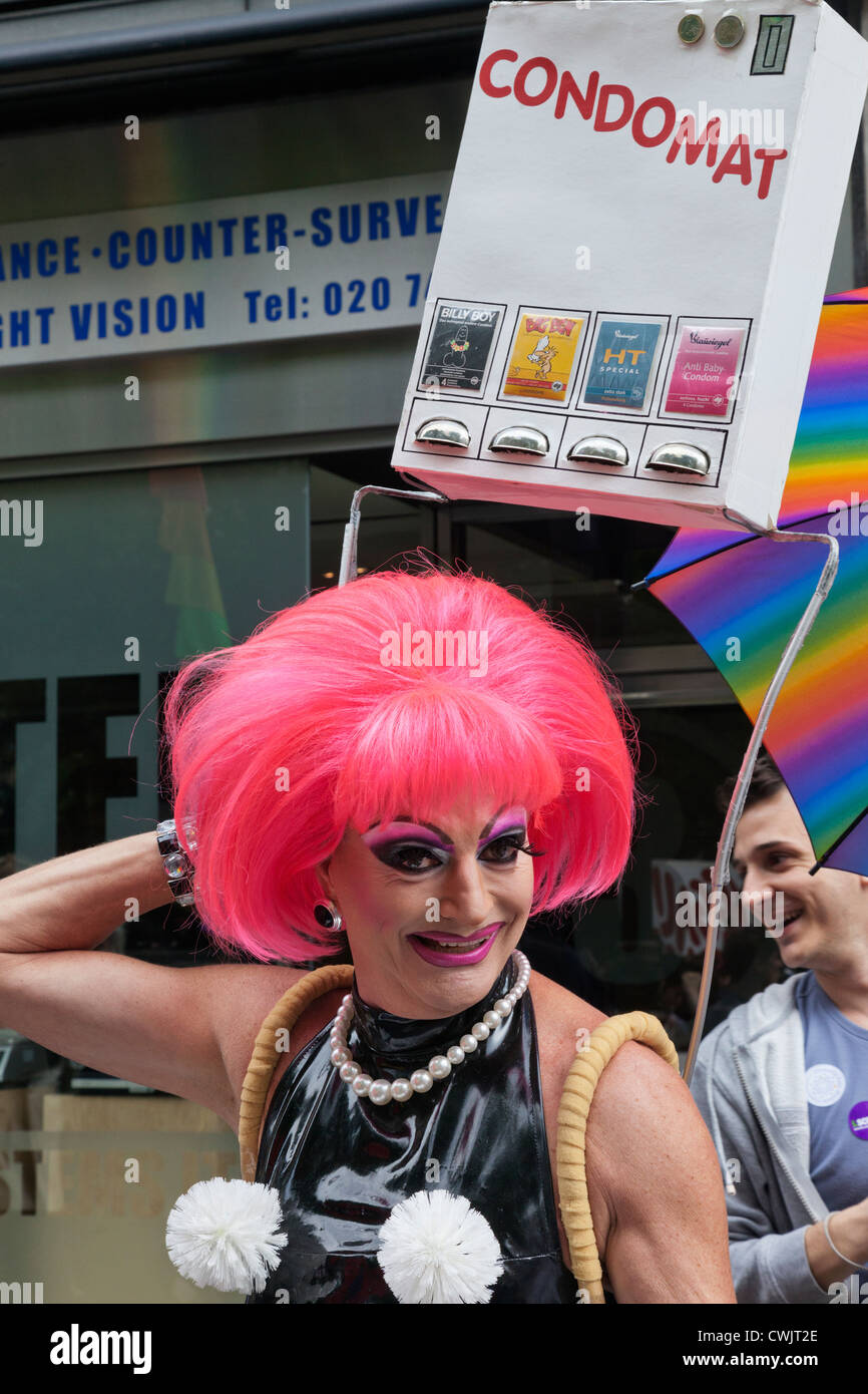 L'Angleterre, Londres, la Gay Pride Parade annuelle, imitateur femelle transportant des Machine Condom Banque D'Images