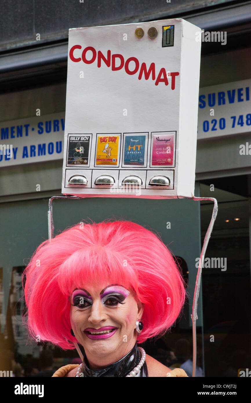 L'Angleterre, Londres, la Gay Pride Parade annuelle, imitateur femelle transportant des Machine Condom Banque D'Images