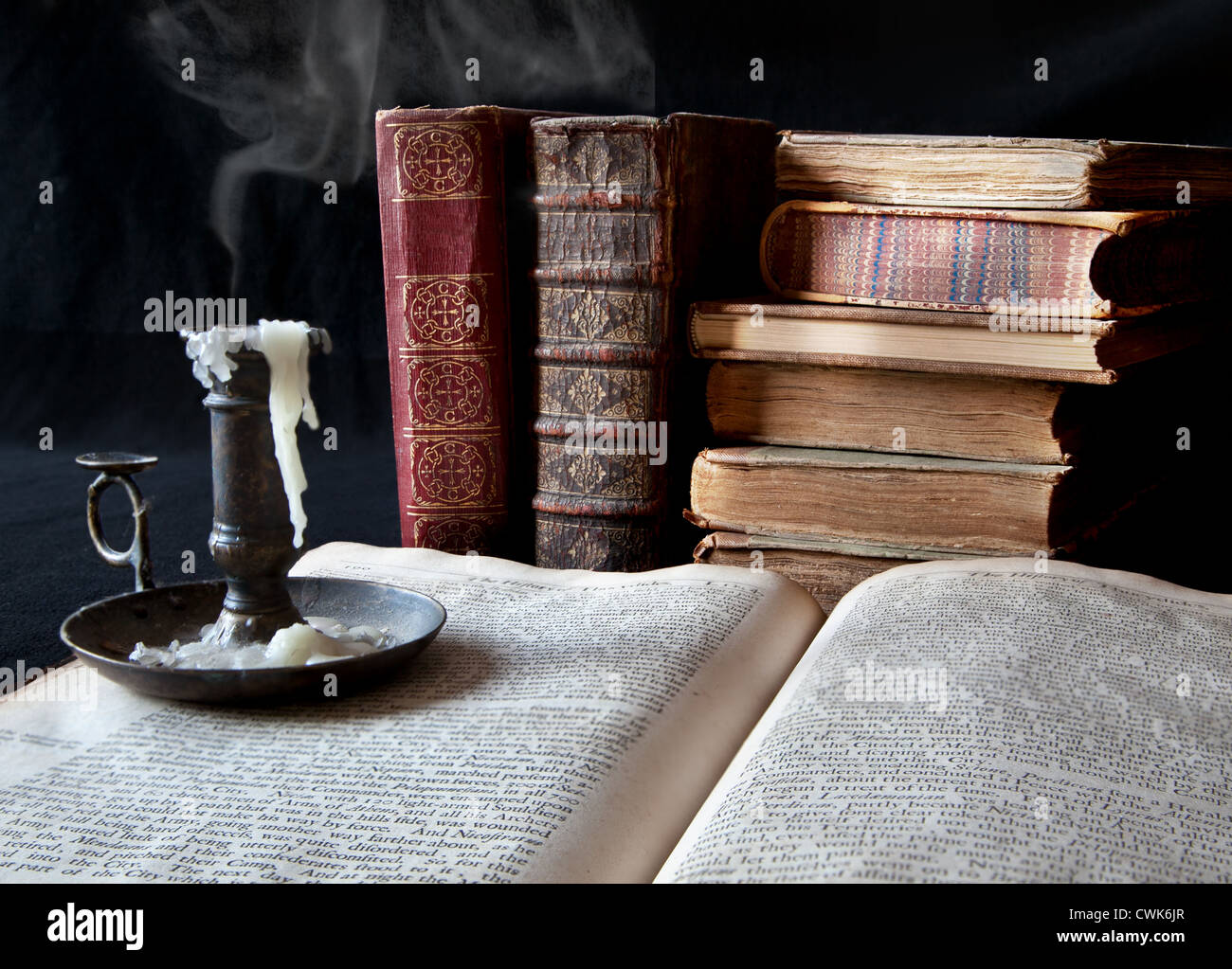 La fumée d'une chandelle éteinte dérive plus de livres anciens Banque D'Images