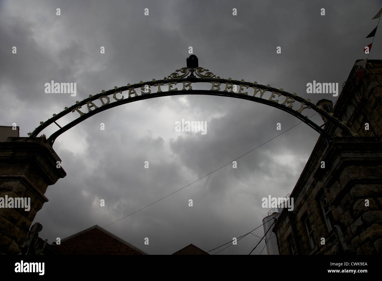 Les portes en fer forgé ornemental à Tadcaster brewery découpé sur un ciel d'orage Banque D'Images