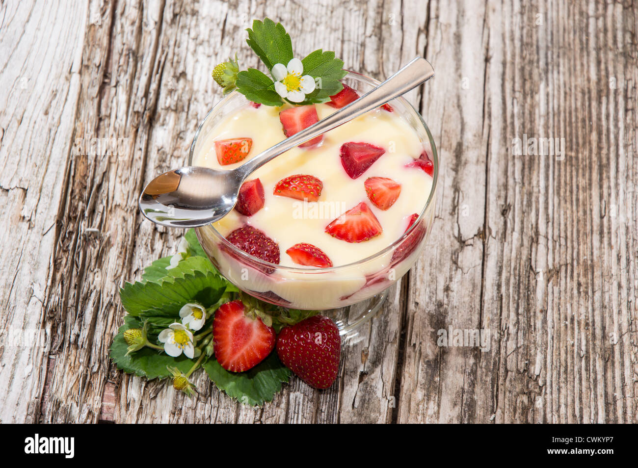 Pouding à la vanille avec des fraises sur fond de bois Banque D'Images