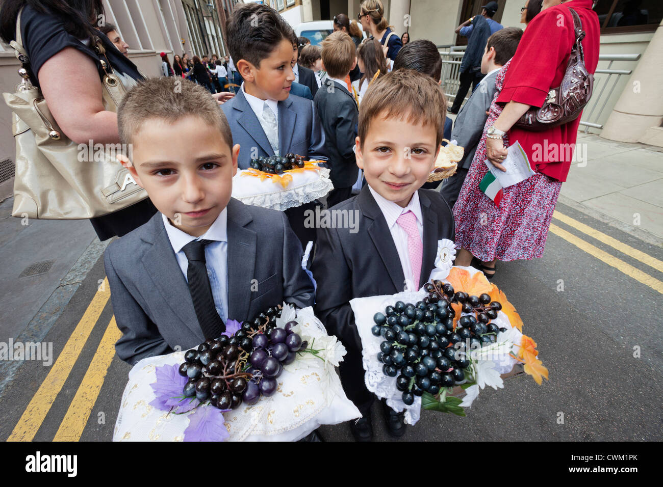 Londres, Clerkenwell, l'Italien annuel Dame du Carmel Procession Festival, deux jeunes garçons portant des plateaux d'Grapes Banque D'Images