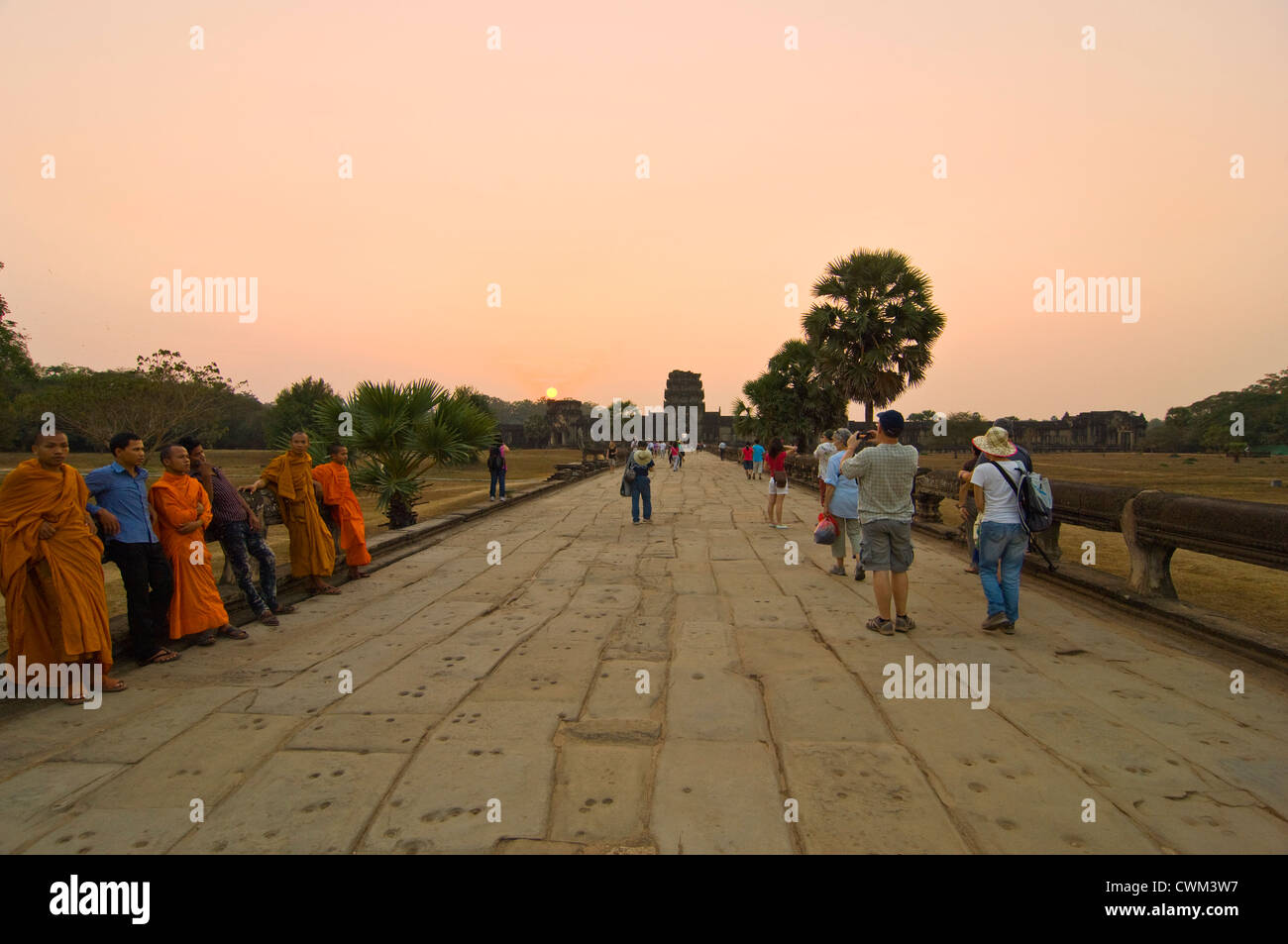 Vue horizontale de moines assis le long de la chaussée de Naga dans le soleil du soir à Angkor Wat Banque D'Images