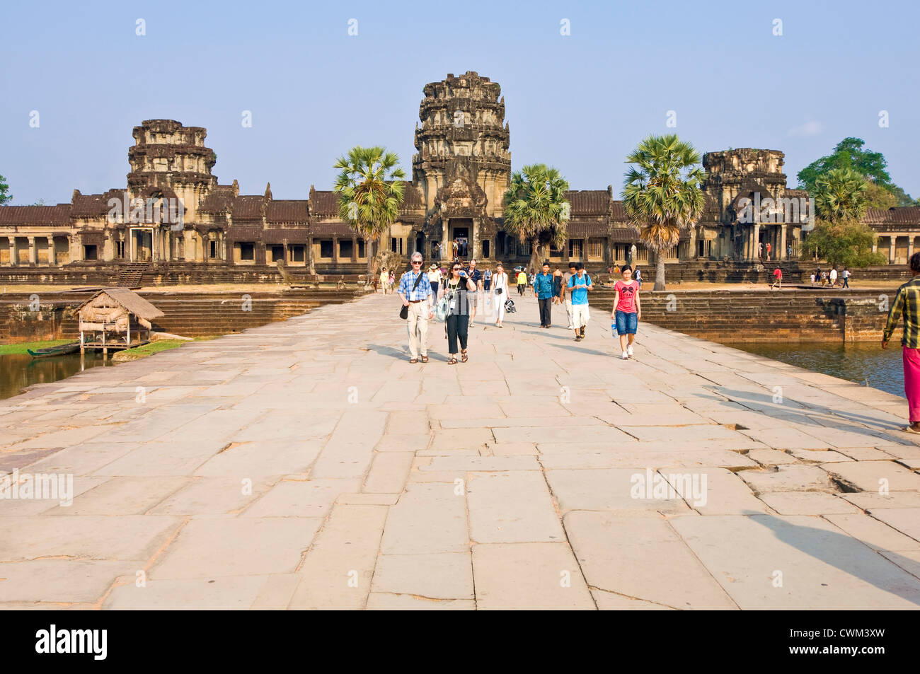 Vue horizontale de touristes marcher le long de la chaussée principale à l'ouest de l'entrée dans le Gopuram, Angkor Wat. Banque D'Images
