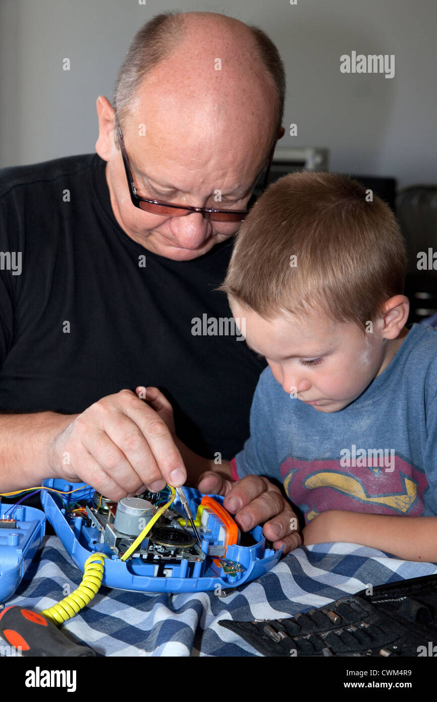 Petit-fils d'aider grand-père réparer son recorder l'âge de 58 et 6. Zawady Centre de la Pologne Banque D'Images