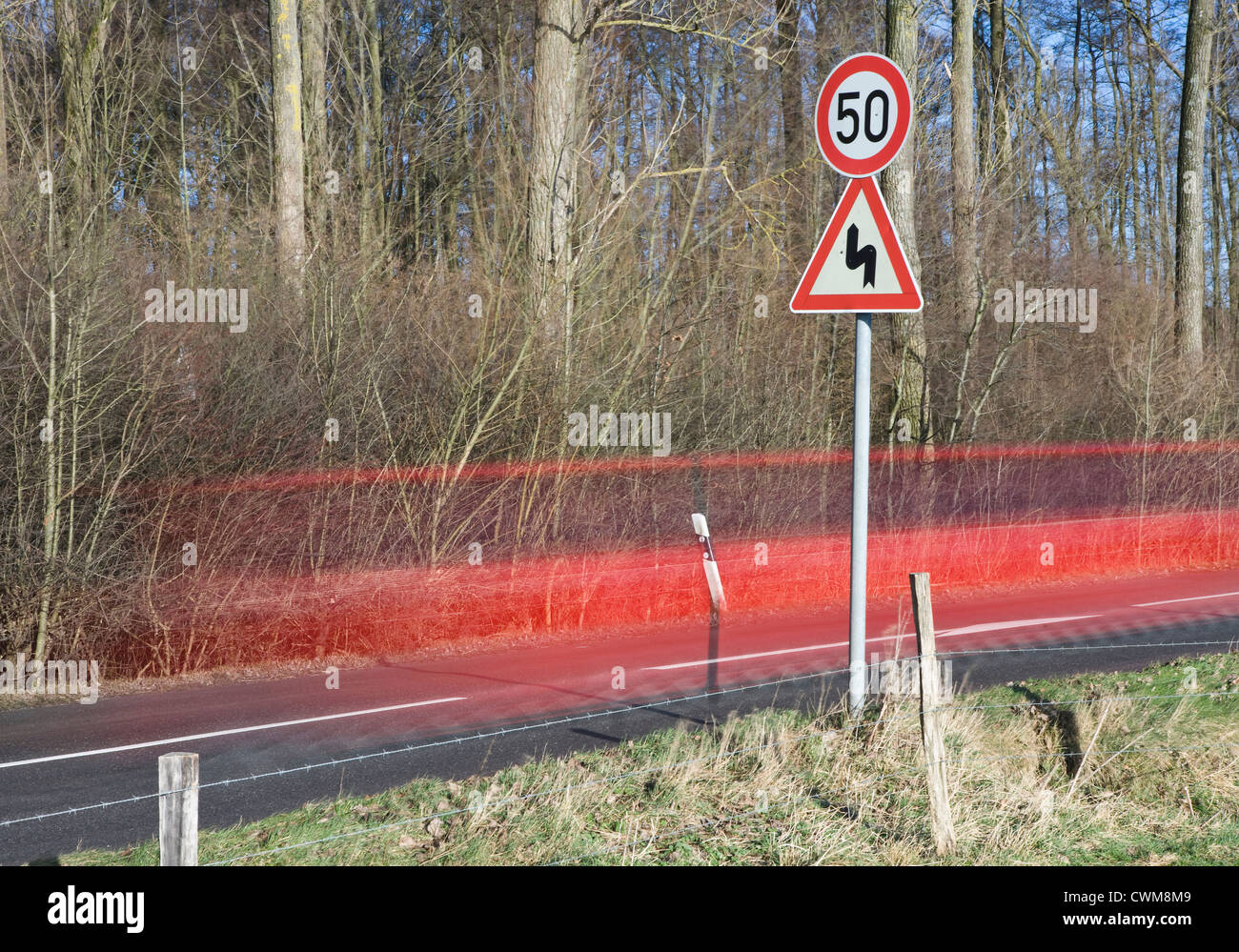 Allemagne, voiture rouge passant par country road Banque D'Images