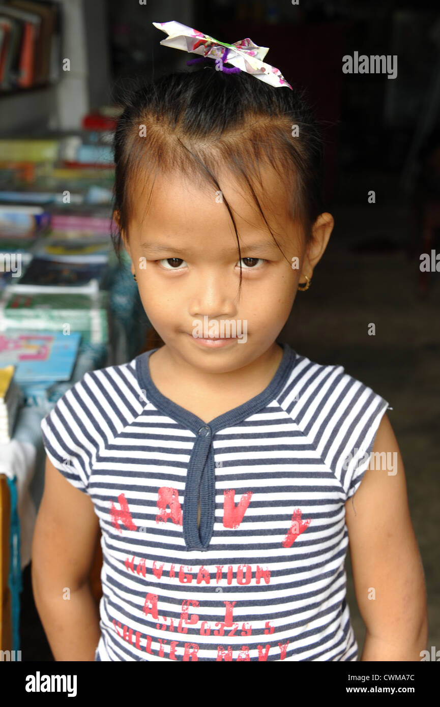 Petite fille avec un Lao home-made paper butterfly pince à cheveux. Banque D'Images