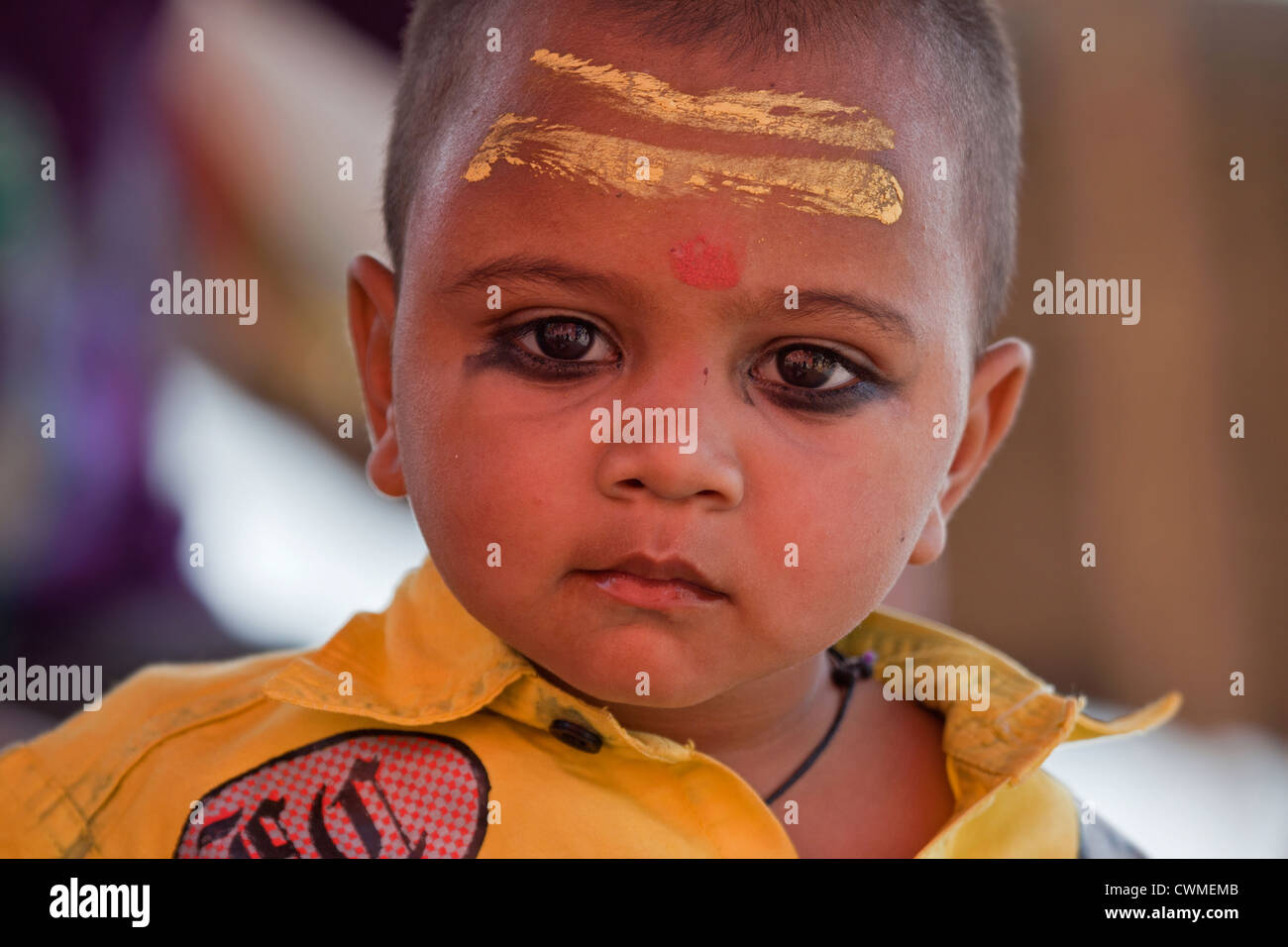 Porter l'enfant hindou bindi et peint jaune sur le front à Varanasi, Uttar Pradesh, Inde Banque D'Images