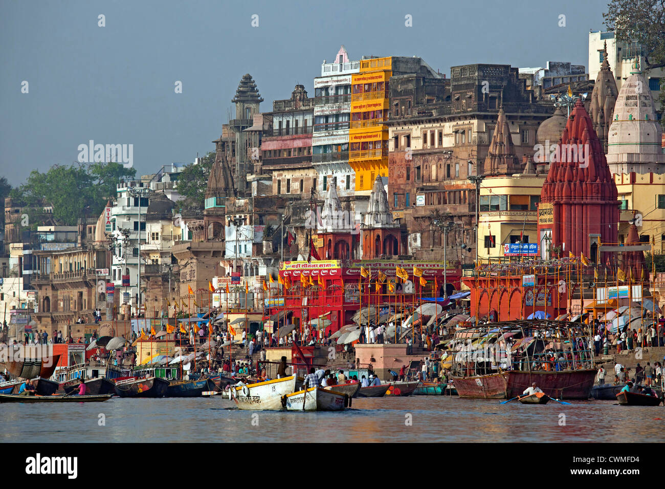 Pèlerins visitant la ville sainte et des barques colorées sur le Gange à Varanasi, Uttar Pradesh, Inde Banque D'Images