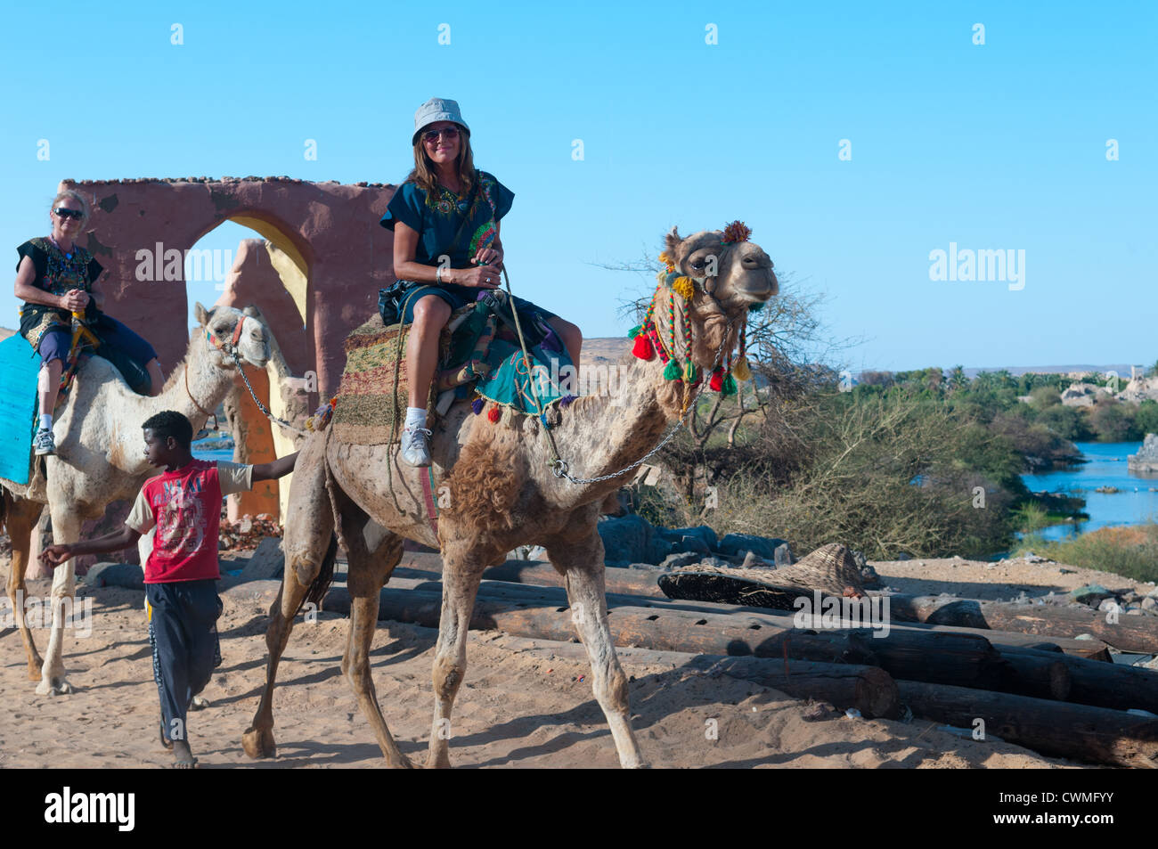 Les touristes chameaux Gharb Soheil Nubian Village sur la rive ouest du Nil à Assouan Egypte suivant Banque D'Images