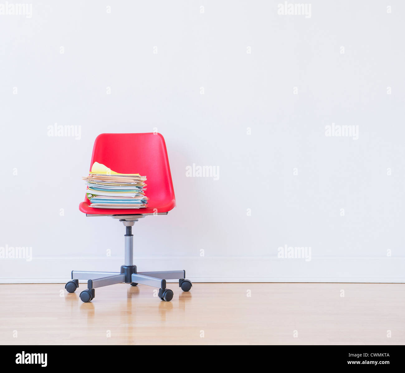 Studio shot of pile de livres sur la chaise de bureau rouge Banque D'Images