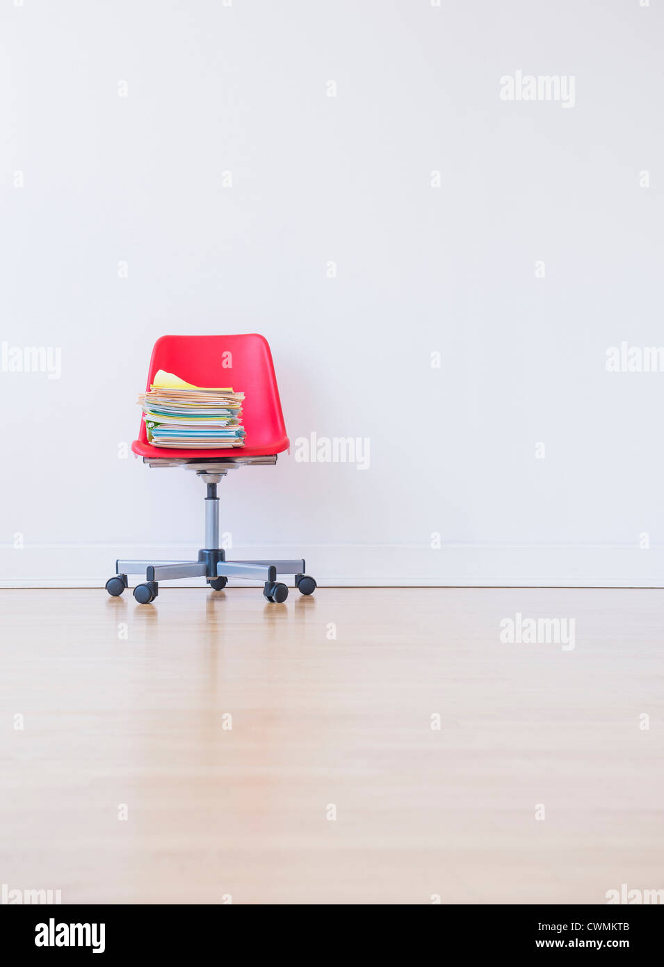 Studio shot of pile de livres sur la chaise de bureau rouge Banque D'Images