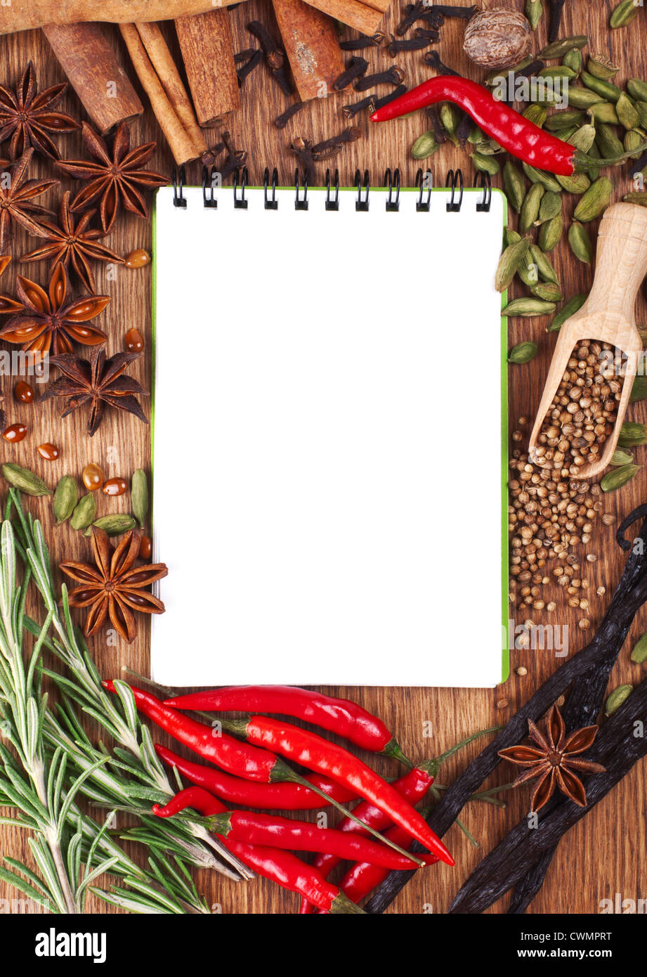 Ordinateur portable ouvert avec des épices et herbes sur la vieille planche à découper en bois Banque D'Images