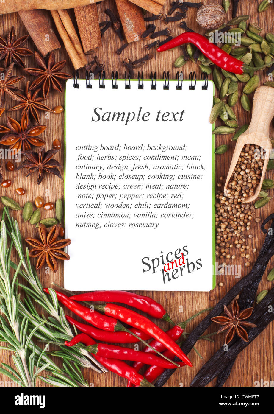 Ordinateur portable ouvert avec des épices et herbes sur la vieille planche à découper en bois Banque D'Images