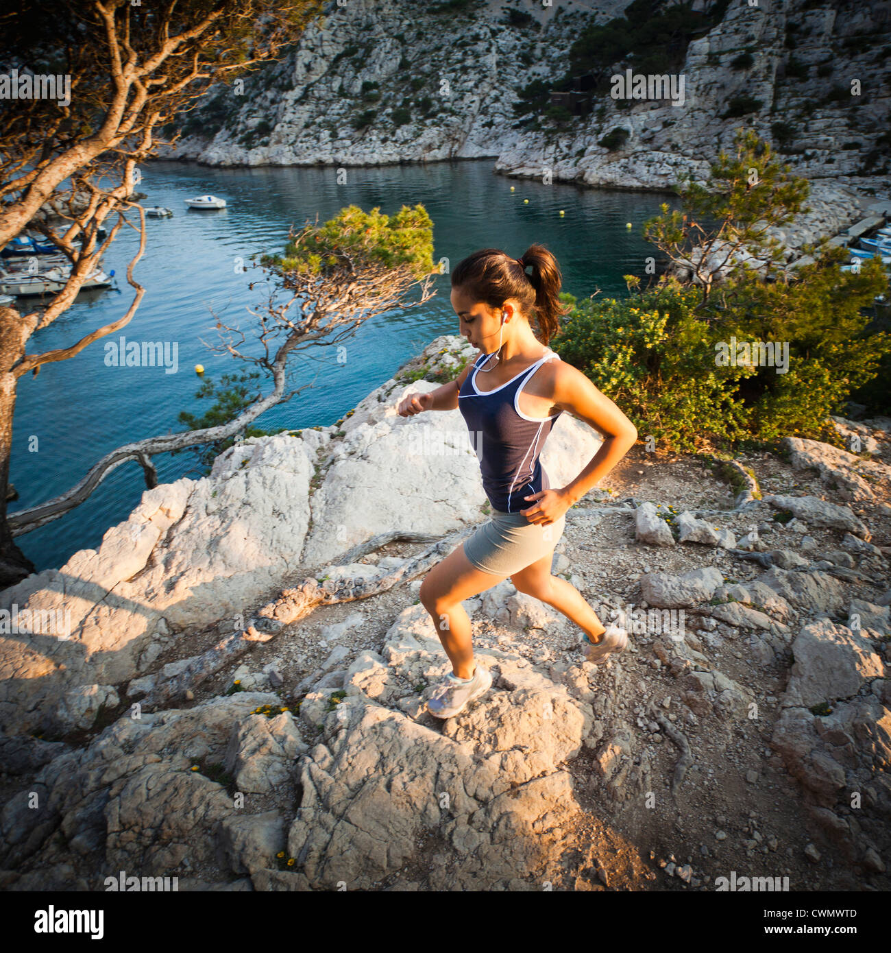 France, Marseille, young woman jogging en terrain rocheux Banque D'Images