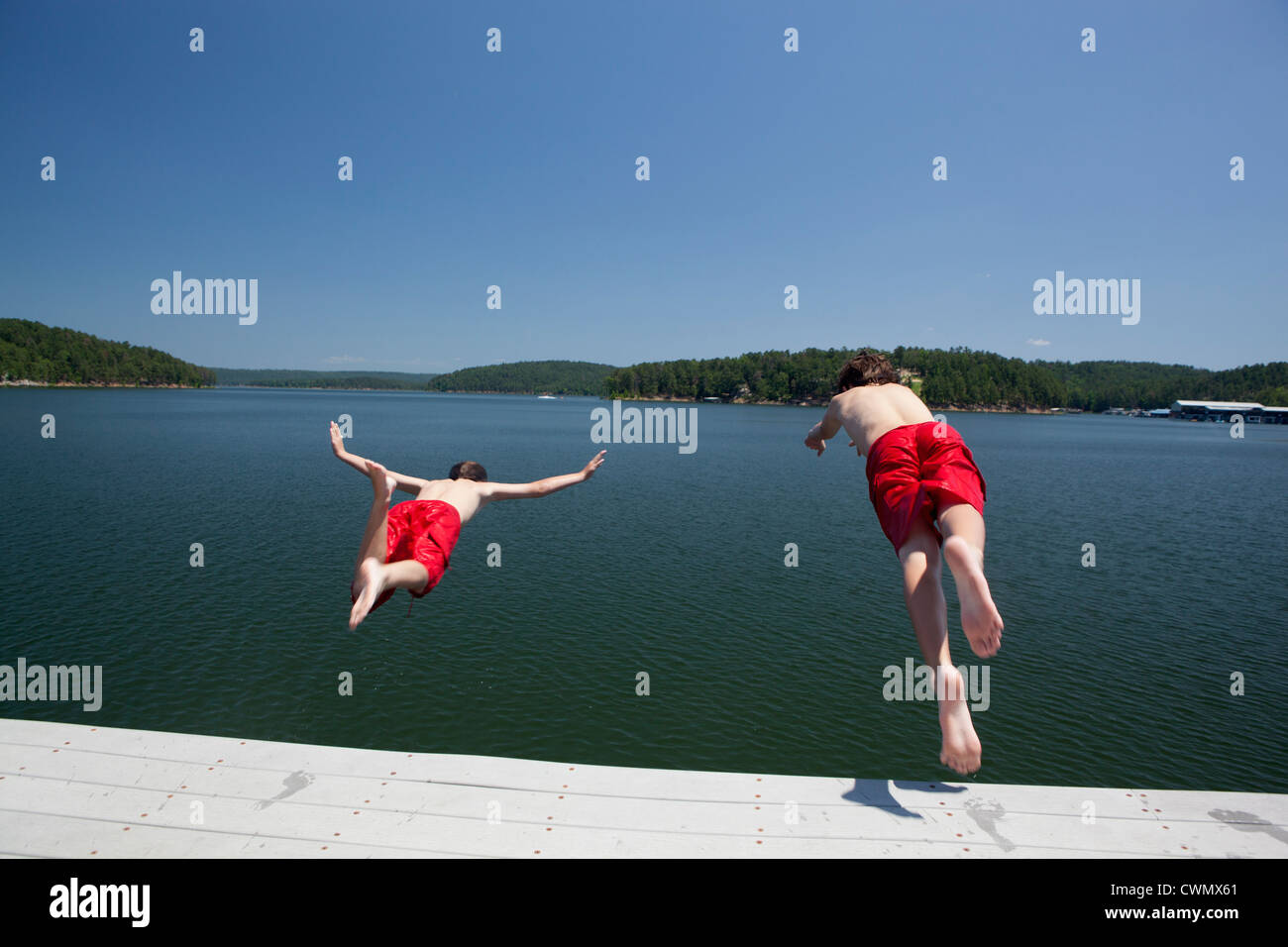 USA, Ohio, Murfreesboro, deux frères (8-9, 12-13) sauter dans l'eau Banque D'Images