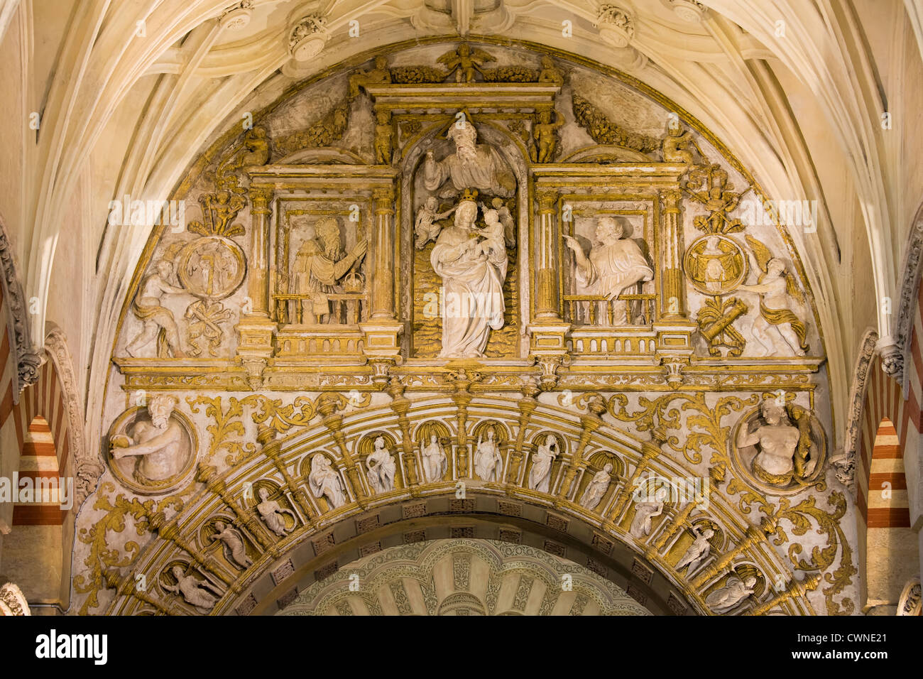 Ornements richement décorées d'espace entre les deux arches avec reliefs religieux à l'intérieur de la cathédrale mezquita de Cordoue, Espagne. Banque D'Images