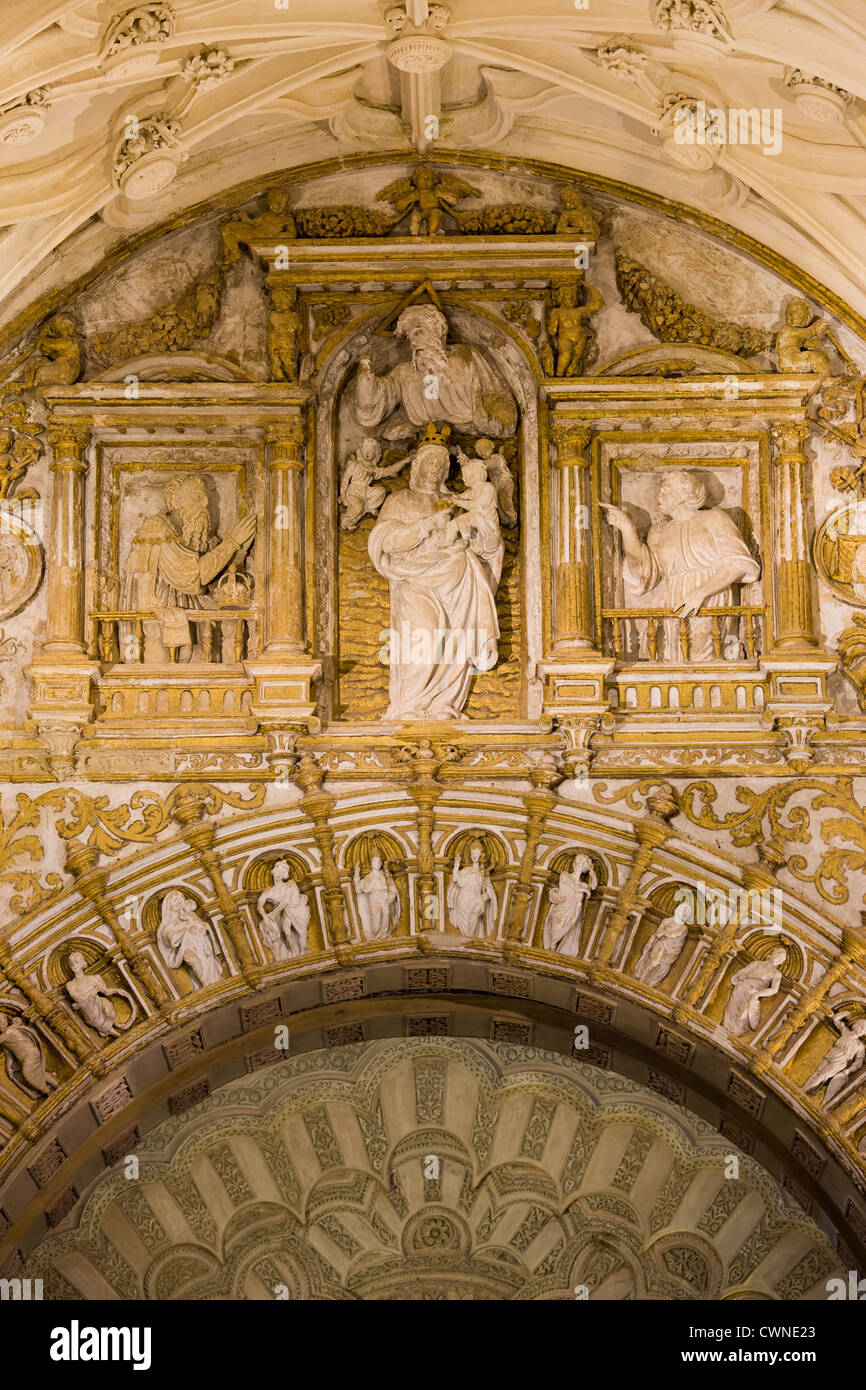 Ornements richement décorées d'espace entre les deux arches avec reliefs religieux à l'intérieur de la cathédrale mezquita de Cordoue, Espagne. Banque D'Images