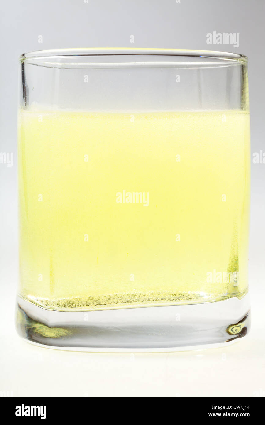 Verre d'eau gazeuse jaune sur fond gris Banque D'Images