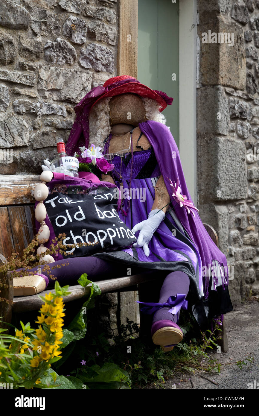 Jenny Joseph. Femme en violet "Prenez un vieux sac shopping' Yorkshire UK ; tableau vivant 2012 Kettlewell épouvantail annuel festival, Yorkshire du Nord. Banque D'Images