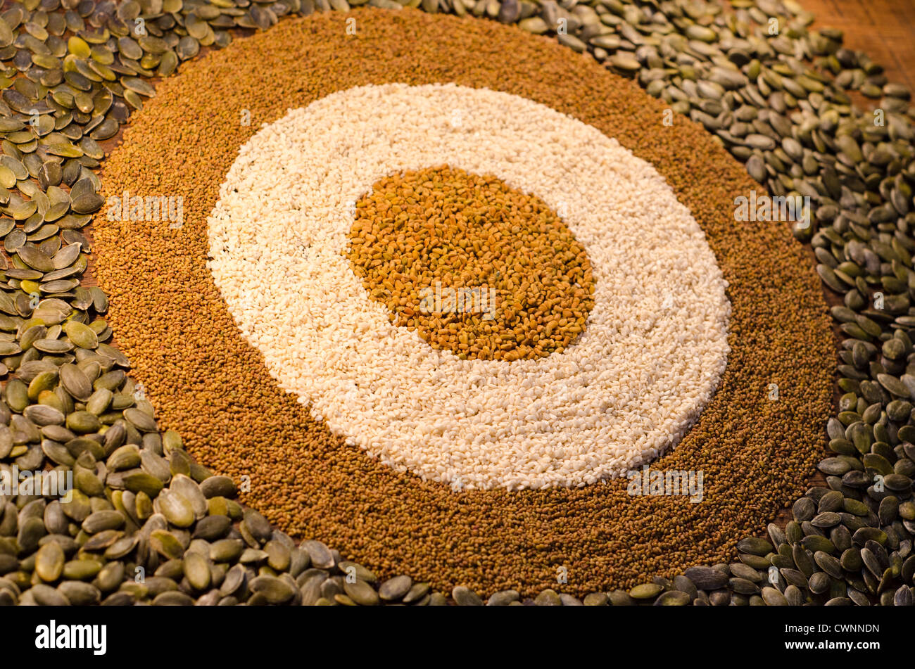Une circulaire, motif géométrique à partir d'une variété de graines, y compris les graines de citrouille, graines de sésame, graines de alfaf amd les graines de fenugrec. Banque D'Images