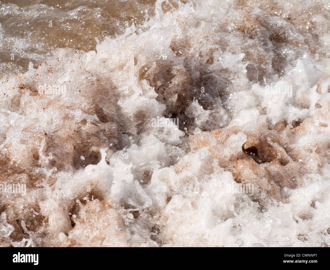 Lors d'un freinage vagues plage je Aqaba en Jordanie et le mélange avec le sable Banque D'Images